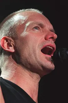 Sting rock singer performing live on stage in Aberdeen with mouth open singing into Sting rock singer performing live on stage in Aberdeen with mouth open singing into