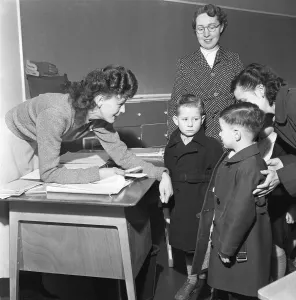 Teacher greets a new addition to her class and introduces him to one of his new class Teacher greets a new addition to her class and introduces him to one of his new class