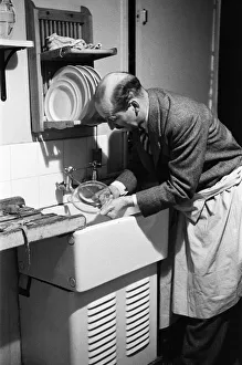 Ted Castle, the husband of Barbara Castle, doing the washing up at the kitchen sink Ted Castle, the husband of Barbara Castle, doing the washing up at the kitchen sink