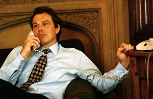 Tony Blair sitting on the sofa holding a telephone handset to his ear Tony Blair sitting on the sofa holding a telephone handset to his ear