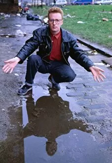 Images Dated 1st July 1990: TV presenter Bryan Burnett kneeling next to puddle 1990