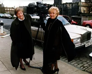 Vera Weisfeld black cape brown suit beside television camera Rolls Royce car Vera Weisfeld black cape brown suit beside television camera Rolls Royce car