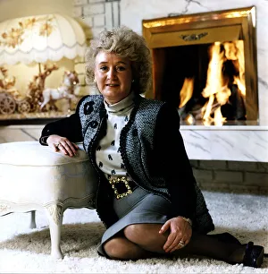 Vera Weisfeld sitting on white fire side rug leaning on foot stool grey Vera Weisfeld sitting on white fire side rug leaning on foot stool grey