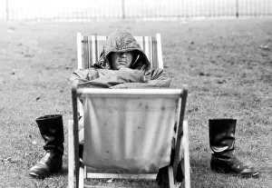 Images Dated 5th August 1971: A weary traveller removes his boots as he takes a rest on a bed made from two deckchairs