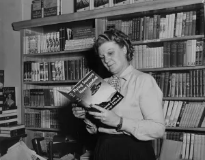 A woman reading a book about flying saucers 1950s A woman reading a book about flying saucers 1950s