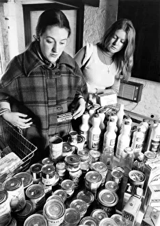 Woman shopping for cans of food, holding a basket. March 1977 P007931 Woman shopping for cans of food, holding a basket. March 1977 P007931