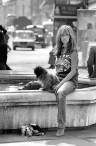 00060 Gallery: Woman stops at a fountain to rest her tired feet after walking her dog around the Kings