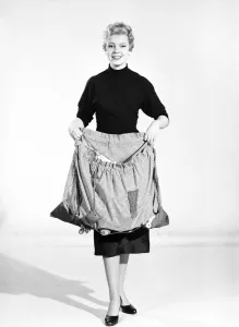 Woman wearing Dutch apron that converts into a bag. 1955 Woman wearing Dutch apron that converts into a bag. 1955