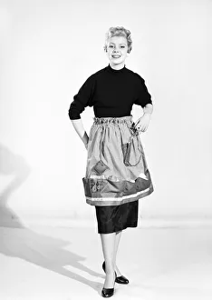 Woman wearing Dutch apron that converts into a bag. 1955 Woman wearing Dutch apron that converts into a bag. 1955