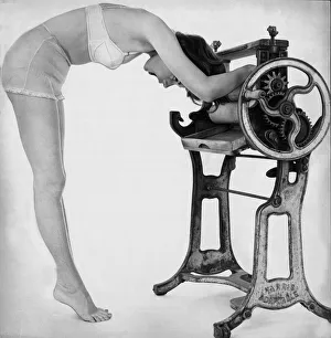A woman wearing underwear drying her through an old fashioned roller machine A woman wearing underwear drying her through an old fashioned roller machine