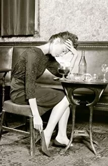 A women who has had to much to drink holds her head (posed by model)