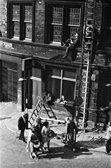 00611 Gallery: A workman perched above the maddening crowds, takes a lunchtime snooze in the warm