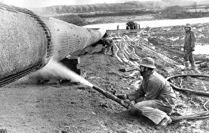 A workman sprays on the gas pipelines concrete coat in December 1974 A workman sprays on the gas pipelines concrete coat in December 1974