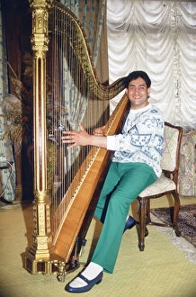 World snooker champion Joe Johnson poses playing a harp. 28th May 1986