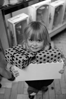 Three year old Mandie Keating of Boreham Wood with her arms full of parcels doing some Three year old Mandie Keating of Boreham Wood with her arms full of parcels doing some