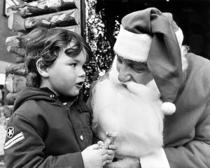 Three year old Matthew whispers his Christmas wishes to Father Christmas Three year old Matthew whispers his Christmas wishes to Father Christmas