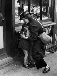 00573 Gallery: Twenty four year old warden Mrs Mary Couchman crouches down to protect her young son