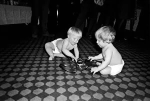 Images Dated 29th April 1975: Two young babies seen here examining a camera at a gathering of them parents of a West