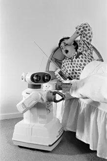 Images Dated 21st October 1986: A young boy in bed being woken by an Omnibot 2000 toy robot. 21st October 1986