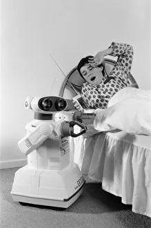 Images Dated 21st October 1986: A young boy in bed being woken by an Omnibot 2000 toy robot. 21st October 1986