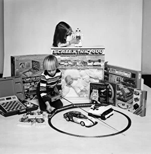 A young boy and girl with a selection of children's toys for Christmas. December 1980