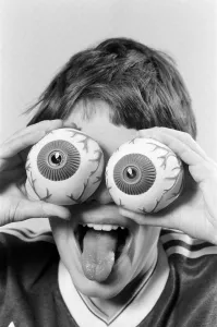 Images Dated 21st October 1986: A young boy holding fake eye ball toys up to his eyes. 21st October 1986