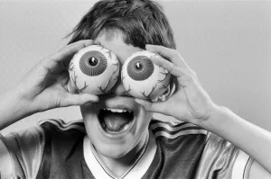 Images Dated 21st October 1986: A young boy holding fake eye ball toys up to his eyes. 21st October 1986