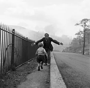 A young boy running into the arms of a man. Ebbw Vale, Blaenau Gwent, Wales A young boy running into the arms of a man. Ebbw Vale, Blaenau Gwent, Wales