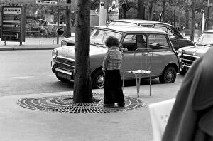 Images Dated 21st April 1975: Young boy urinates outside a cafe on the Champs Elysees in Paris, France