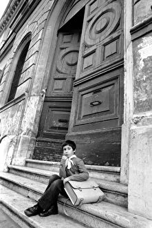 Images Dated 1st April 1975: Young child sitting on the steps of an old building in a poor suburb on the outskirts of