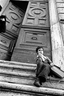 Images Dated 1st April 1975: Young child sitting on the steps of an old building in a poor suburb on the outskirts of