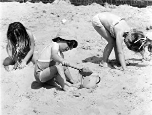 Images Dated 26th June 1979: Young children playing in the sand, building sandcastles with a bucket