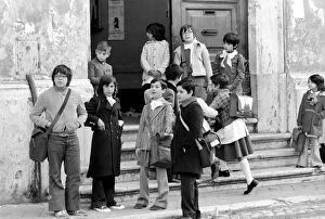 Young children on the steps of their school building in a poor suburb on the outskirts