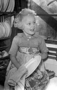 Young girl helping out a home by doing the washing up Circa 1945 P044422 Young girl helping out a home by doing the washing up Circa 1945 P044422