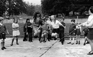 Young girl jumping over a skipping rope in the playground of the National School at