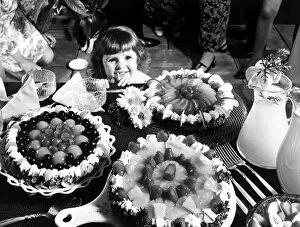 Images Dated 1st August 1970: A young girl looking at a table with cakes. 1970