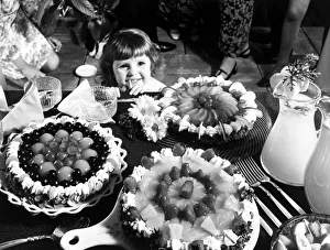 Images Dated 1st August 1970: A young girl looking at a table with cakes Circa 1970