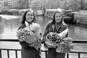 00068 Gallery: Two young girls of Amsterdam holding bunches of tulips during the season May 1975