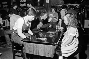 Images Dated 12th August 1981: Young holidaymakers play the video machines at the James Corrigan seafront amusement