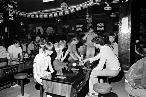 Images Dated 12th August 1981: Young holidaymakers play the video machines at the James Corrigan seafront amusement