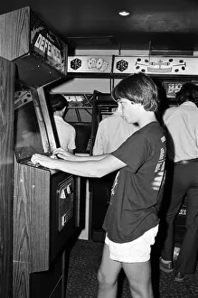 Young people playing video games in an amusement arcade in London. 13th July 1983 Young people playing video games in an amusement arcade in London. 13th July 1983