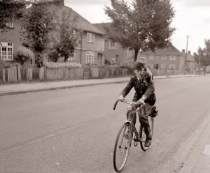 A young schoolboy comes home from school on his bicycle A young schoolboy comes home from school on his bicycle