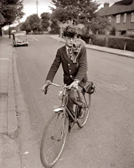 A young schoolboy comes home from school on his bicycle A young schoolboy comes home from school on his bicycle