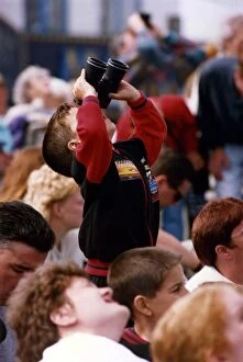 A young spectator looks through a pair of binoculars at an air display at the Sunderland
