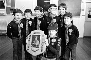 Young Timothy Hutton displays a Holme Valley cub scout swimming trophy watched by other