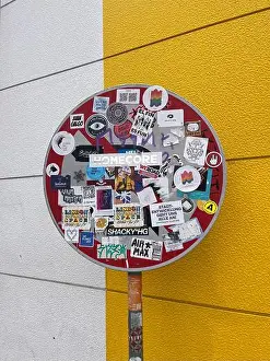Prints of Urban stop sign covered in colorful stickers against a vibrant yellow and white background. Street art and city culture captured in a bold, way Pop Art Prints: Urban Stop Sign Print with Colorful Stickers