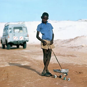 Mogadishu Collection: Mogadishu. Along a track of sand, a boy and a rudimentary toy