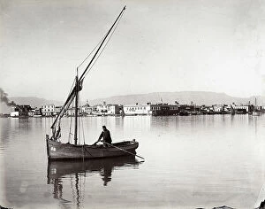 Suez Collection: Panoramic view of a town on the Suez Canal, in Egypt. A man is photographed on board a boat