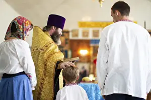 Prints of Belarus, Goncharnaya village. Orthodox baptism of a child. September 19, 2018.Orthodox rite of baptism in the Slavic church. The priest reads a prayer to the boy and his godparents in the church Belarus Prints: Belarus, Goncharnaya Village: Orthodox Baptism Print