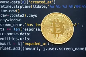 Bitcoin Symbol Prints: A Bitcoin coin on top of computer programming code
